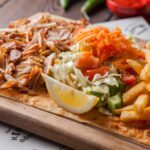 imgi_34_side-view-fried-chicken-pieces-with-lemon-french-fries-salad-wood-plate_176474-3074